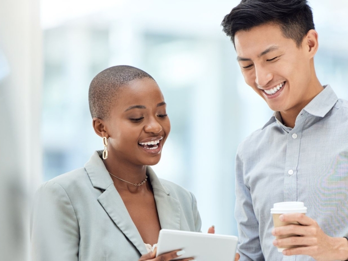 Two people talking and looking at tablet screen. 