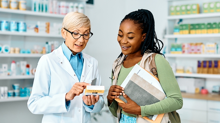 Pharmacist going over medication with patient or caregiver.